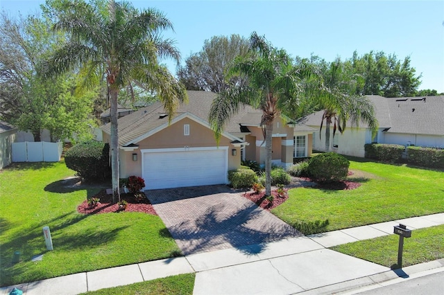 ranch-style home with stucco siding, a front lawn, decorative driveway, fence, and a garage