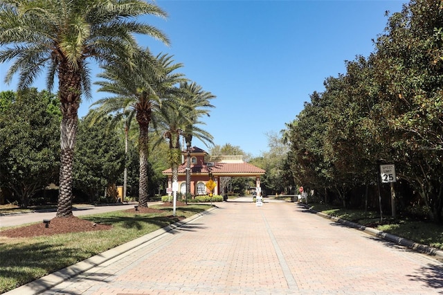 view of street featuring traffic signs, curbs, and a gated entry