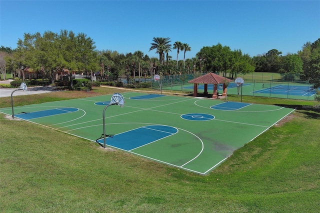 view of sport court with a yard, community basketball court, and fence