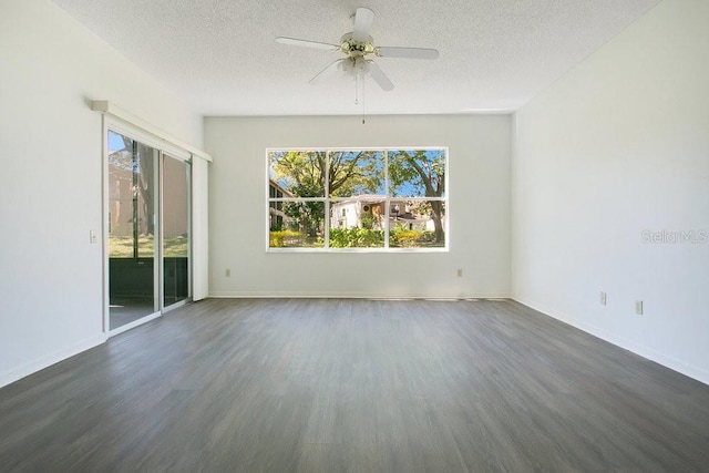 spare room with dark wood-style floors, baseboards, a textured ceiling, and ceiling fan