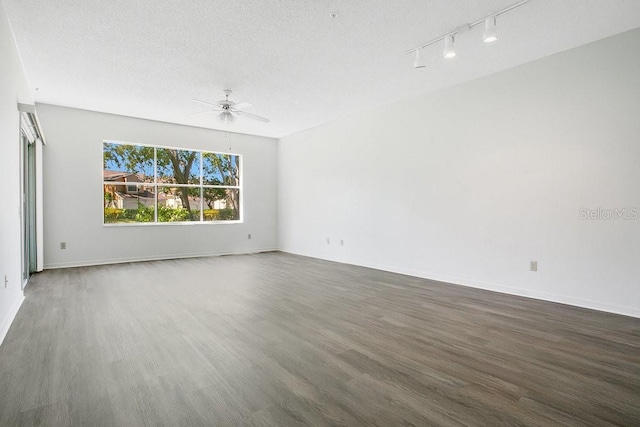 empty room with baseboards, a textured ceiling, ceiling fan, and wood finished floors