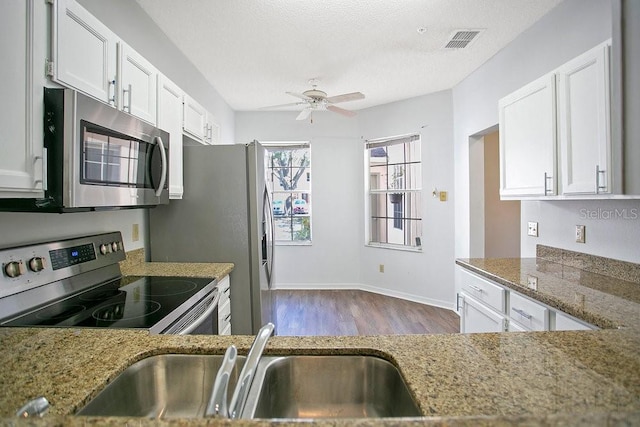 kitchen featuring visible vents, a ceiling fan, a sink, appliances with stainless steel finishes, and white cabinets