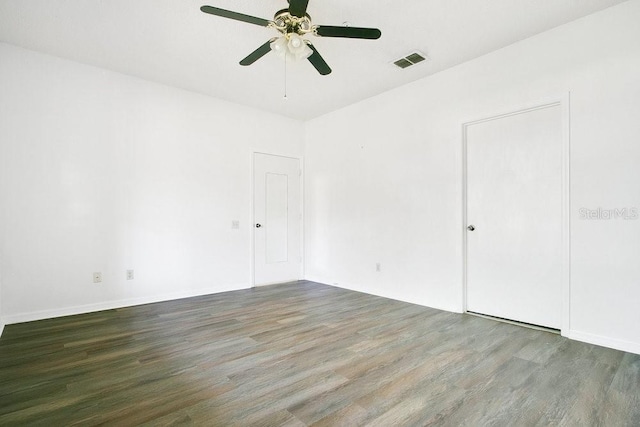 empty room with visible vents, wood finished floors, and a ceiling fan