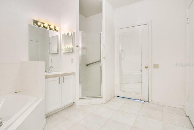 bathroom with a garden tub, vanity, a shower stall, and tile patterned flooring