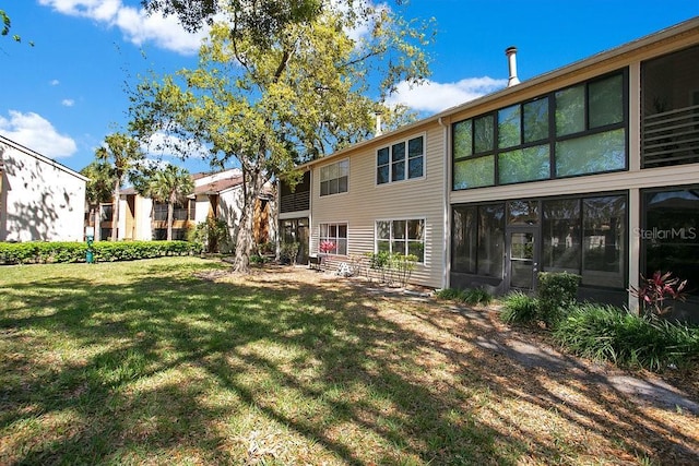 rear view of house featuring a lawn