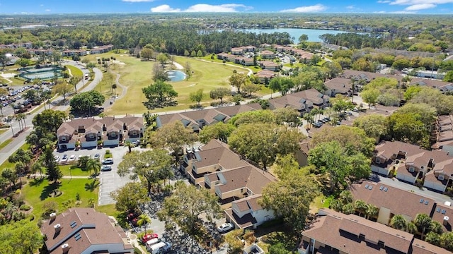 drone / aerial view with a residential view, view of golf course, and a water view