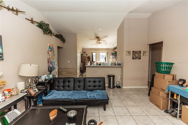 living room with light tile patterned flooring, a ceiling fan, and baseboards