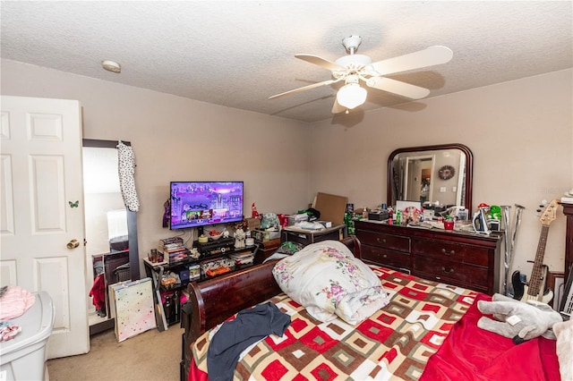 bedroom with a textured ceiling, ceiling fan, and carpet floors