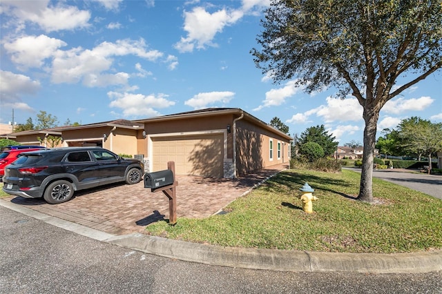 view of front of house with a front yard, decorative driveway, an attached garage, and stucco siding