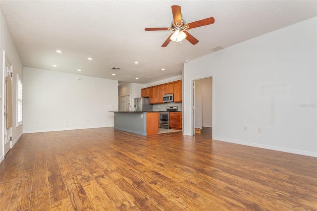 unfurnished living room featuring ceiling fan, baseboards, wood finished floors, and recessed lighting