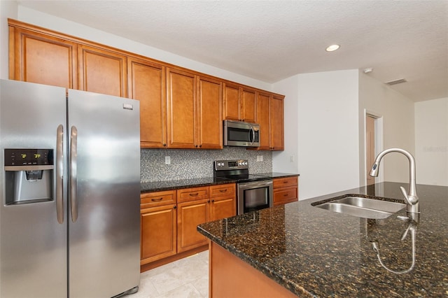 kitchen featuring a sink, stainless steel appliances, backsplash, and brown cabinetry