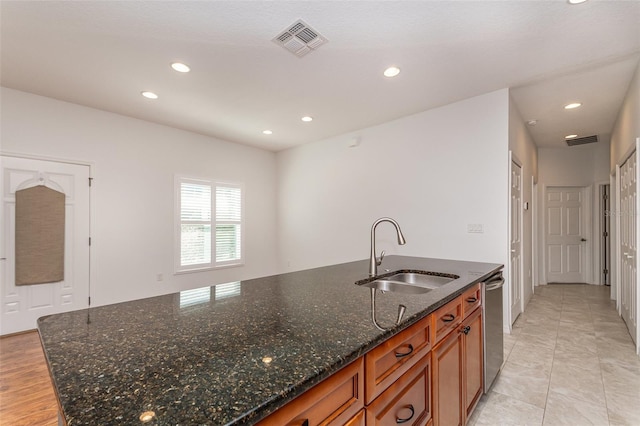 kitchen with dishwasher, brown cabinetry, visible vents, and a sink