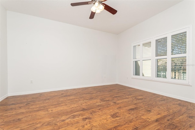 empty room featuring baseboards, wood finished floors, and a ceiling fan