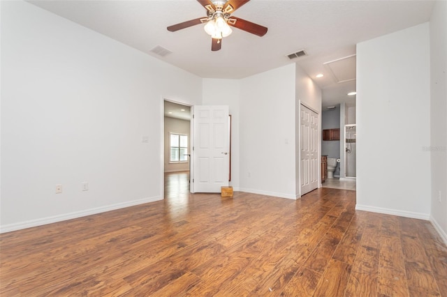 empty room with visible vents, baseboards, wood finished floors, and a ceiling fan