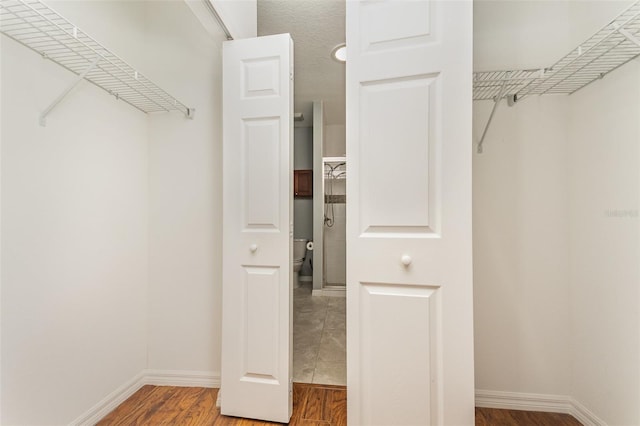 walk in closet featuring wood finished floors