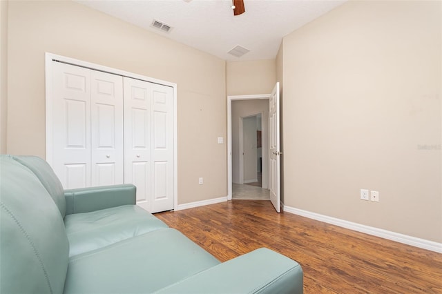 living room with visible vents, baseboards, a ceiling fan, and wood finished floors