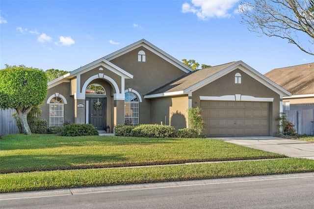 view of front of home with stucco siding, driveway, an attached garage, and a front lawn