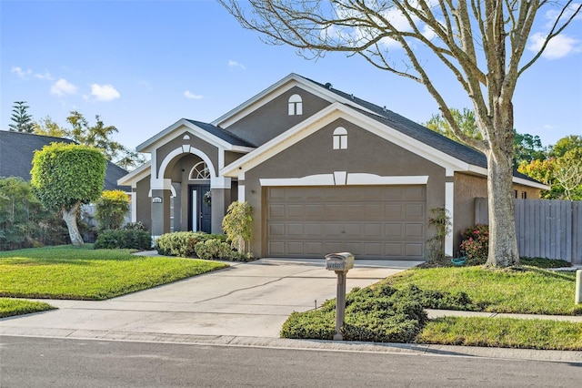 traditional-style home featuring fence, driveway, stucco siding, a front lawn, and a garage