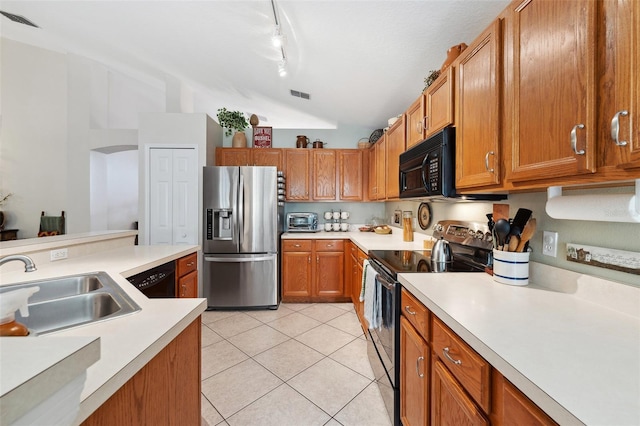 kitchen featuring light tile patterned floors, lofted ceiling, a sink, black appliances, and light countertops