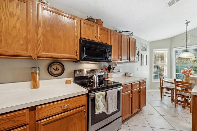 kitchen with visible vents, black microwave, light countertops, light tile patterned floors, and electric range