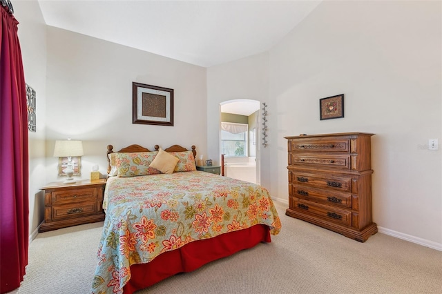 bedroom with carpet, baseboards, and arched walkways