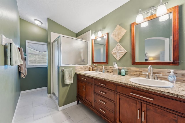 bathroom featuring tasteful backsplash, a stall shower, and a sink