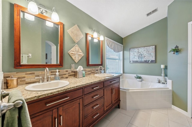 bathroom with a sink, visible vents, lofted ceiling, and a garden tub