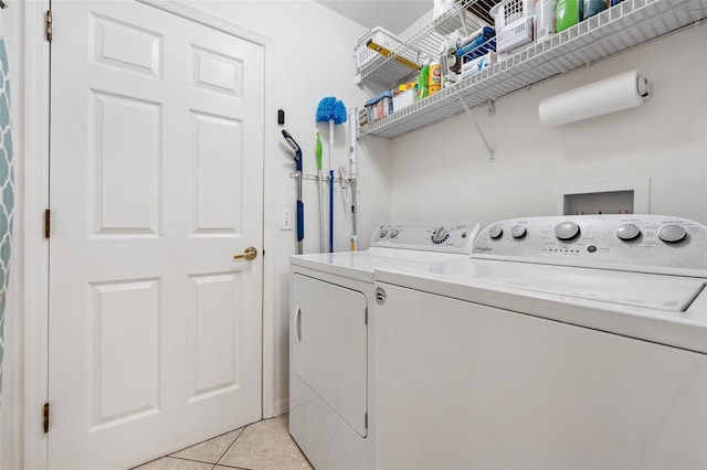 washroom with light tile patterned floors, laundry area, and washer and dryer