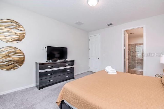 bedroom featuring visible vents, light colored carpet, ensuite bathroom, and baseboards