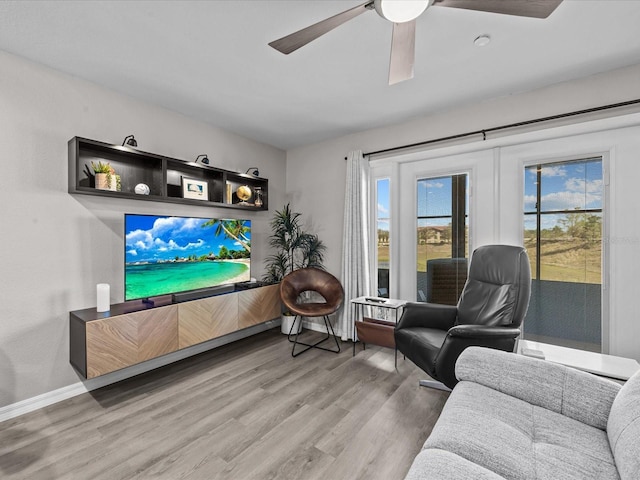 living room with wood finished floors, baseboards, french doors, and ceiling fan