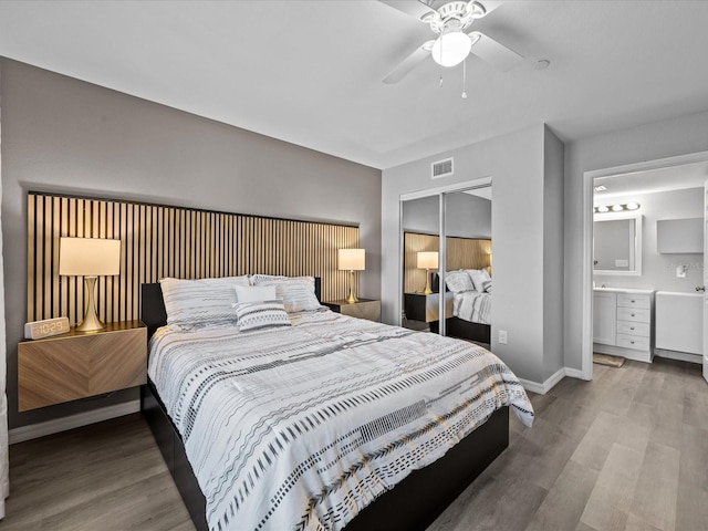 bedroom featuring wood finished floors, visible vents, a closet, and baseboards