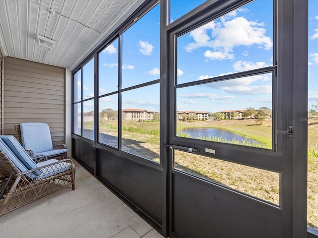 unfurnished sunroom featuring a water view