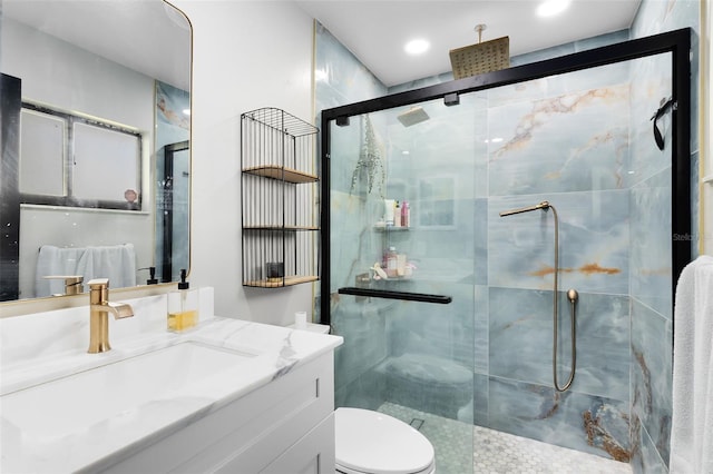 full bath with vanity, a shower stall, and toilet