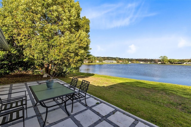 view of patio with a water view and outdoor dining space