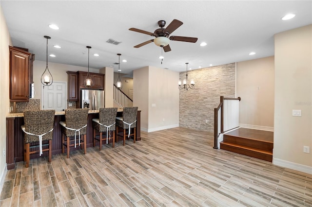 1341 Mill Stream Ln, Winter Springs, FL 32708 - kitchen featuring visible vents, a breakfast bar area, light countertops, ceiling fan with notable chandelier, and stainless steel fridge