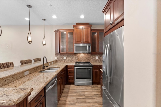 1341 Mill Stream Ln, Winter Springs, FL 32708 - kitchen with light wood finished floors, a peninsula, a sink, stainless steel appliances, and backsplash