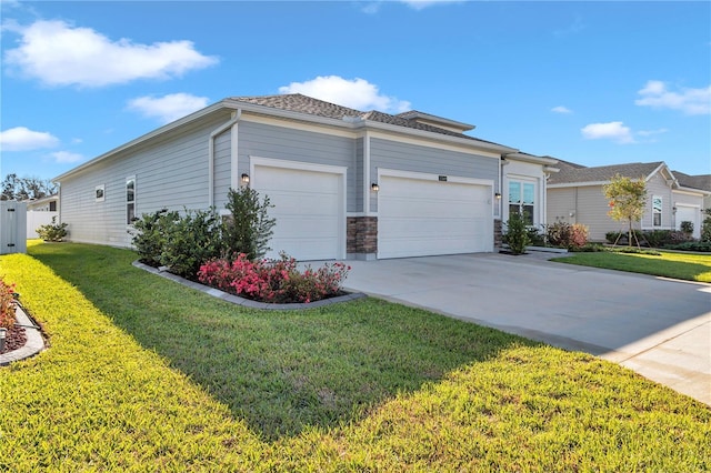 view of front of house featuring stone siding, a front yard, concrete driveway, and an attached garage