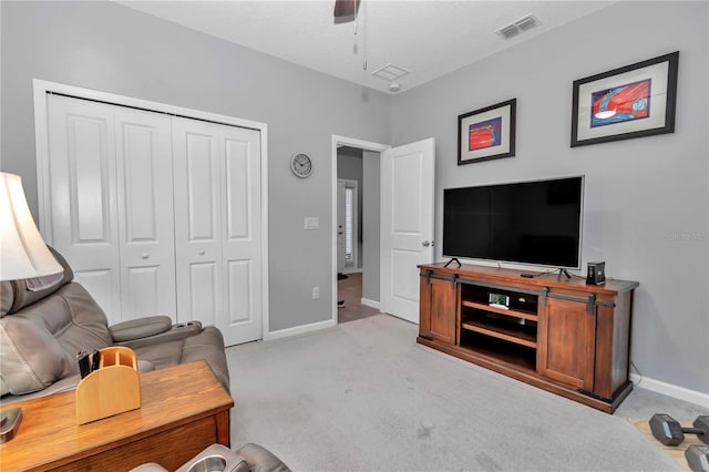 living room with visible vents, baseboards, light colored carpet, and a ceiling fan