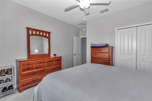 bedroom featuring a closet, carpet floors, visible vents, and a ceiling fan