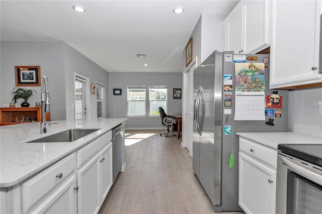 kitchen with visible vents, light wood-type flooring, appliances with stainless steel finishes, white cabinets, and a sink