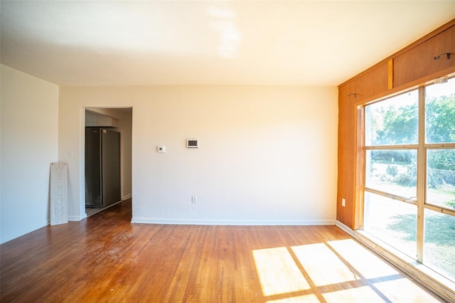 unfurnished room with light wood finished floors and baseboards