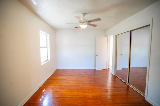 unfurnished bedroom with wood finished floors, a closet, and ceiling fan