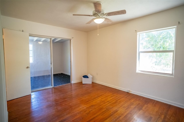 unfurnished bedroom featuring ceiling fan, a closet, baseboards, and wood finished floors