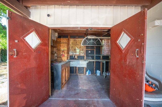 exterior space featuring concrete block wall and concrete flooring