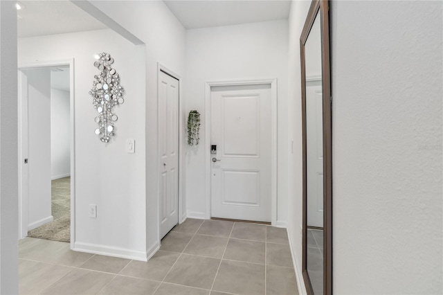 corridor with baseboards and light tile patterned flooring