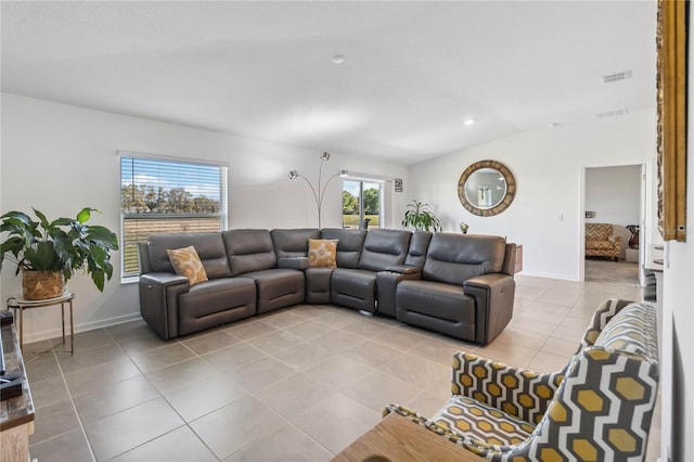 tiled living room with visible vents, baseboards, and lofted ceiling