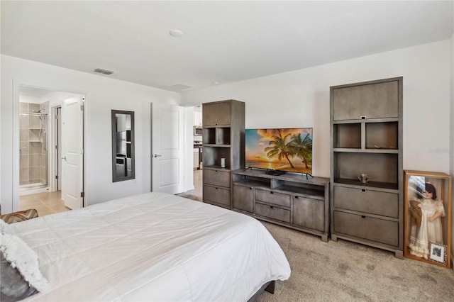 bedroom featuring ensuite bath, light colored carpet, and visible vents