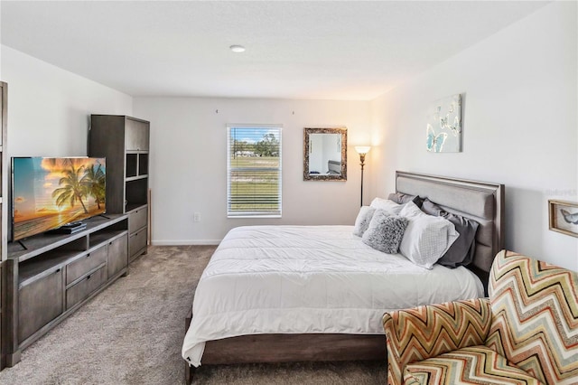 bedroom with light colored carpet and baseboards