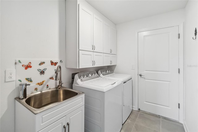 laundry room featuring cabinet space, separate washer and dryer, light tile patterned flooring, and a sink