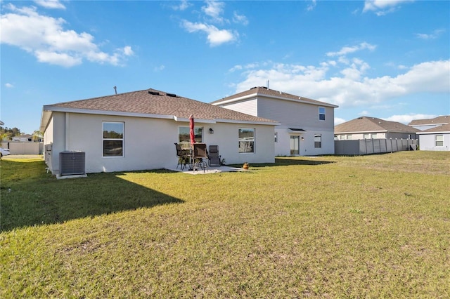 back of house with fence, central air condition unit, a lawn, stucco siding, and a patio area